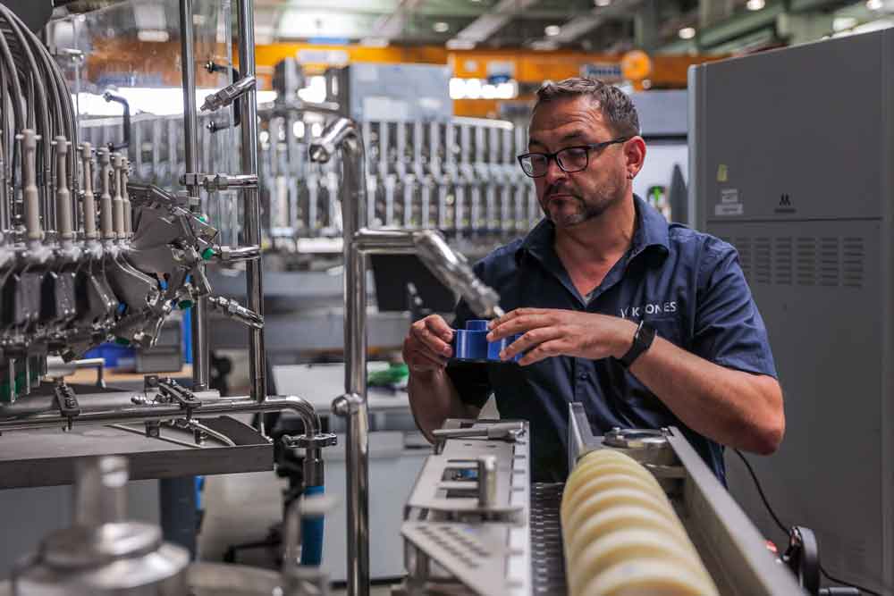 man looks at 3d printed part in factory